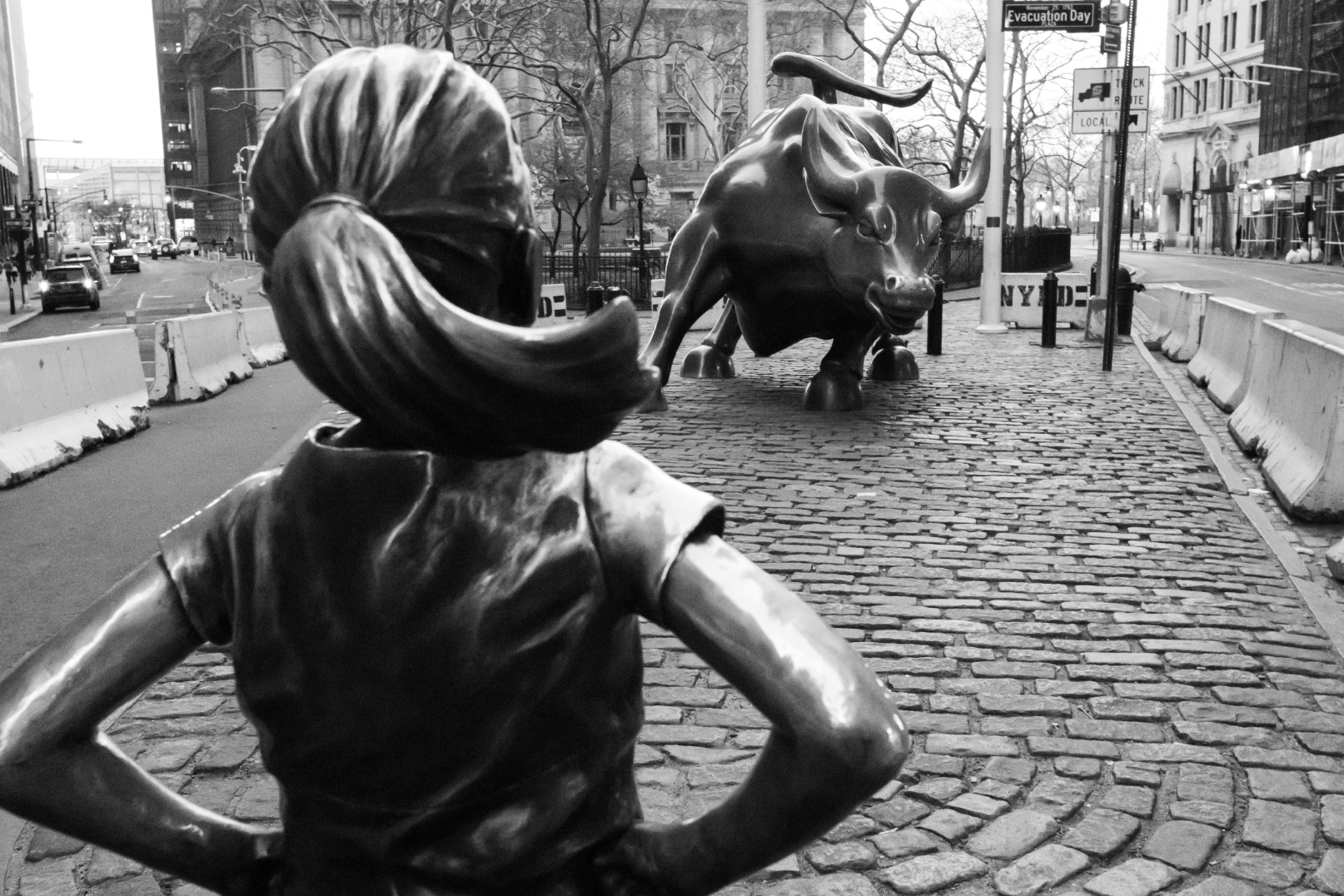Little girl statue looking at the bull statue in NY Stock Exchange